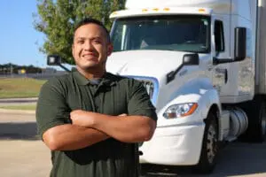 A truck driver standing in front of a semi