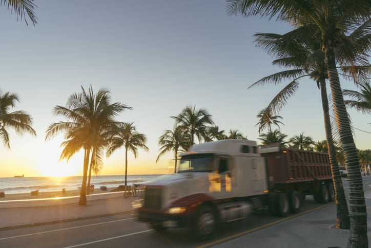 Tractor Trailer drives down the highway with the sunrise in Fort Lauderdale